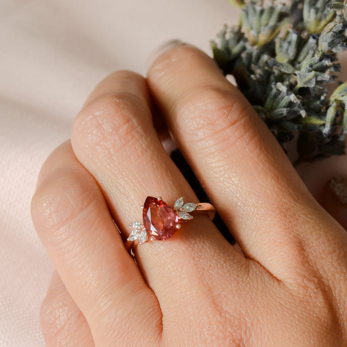 teardrop Padparadscha pink sapphire ring on finger